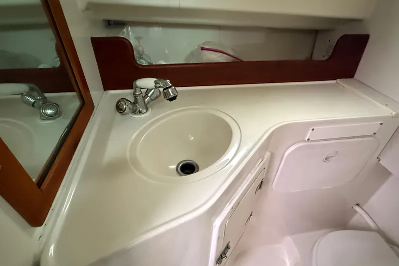 Slide: The Image of 2005 Back Cove 26 boat bathroom with sink, mirror, and storage cabinet. - 64