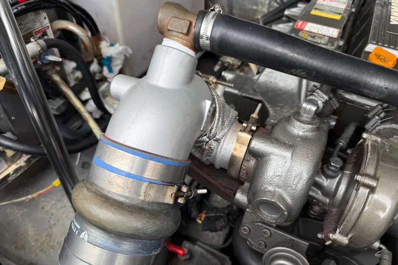 Slide: The Image of Engine components of a 2005 Back Cove 26 boat, featuring hoses and metal fittings. - 69