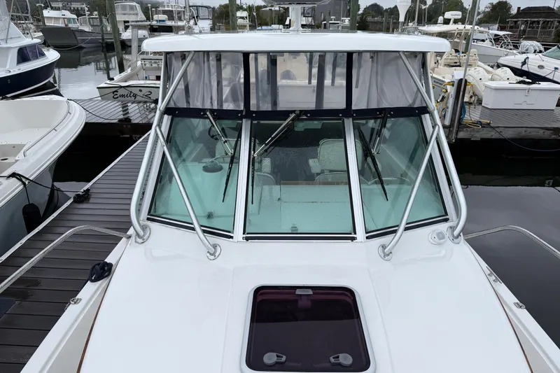 Slide: The Image of 2005 Back Cove 26 boat docked at marina, showcasing windshield and deck. - 9