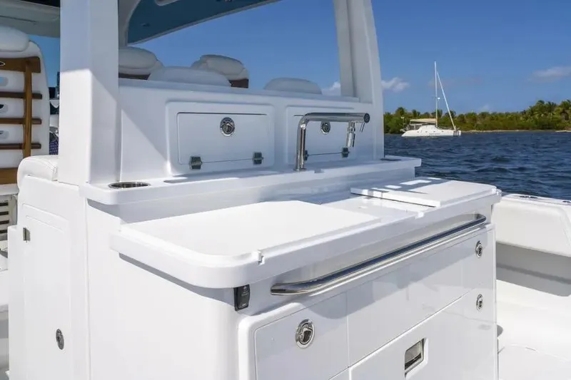 Slide: The Image of 2025 HCB 42 Lujo boat interior with sleek white cabinetry and ocean backdrop. - 22
