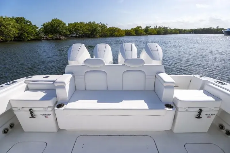 Slide: The Image of 2025 HCB 42 Lujo boat interior with white seating, set against a serene water backdrop. - 29