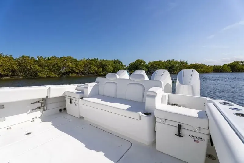 Slide: The Image of 2025 HCB 42 Lujo boat interior with white seating, set against a serene water backdrop. - 30