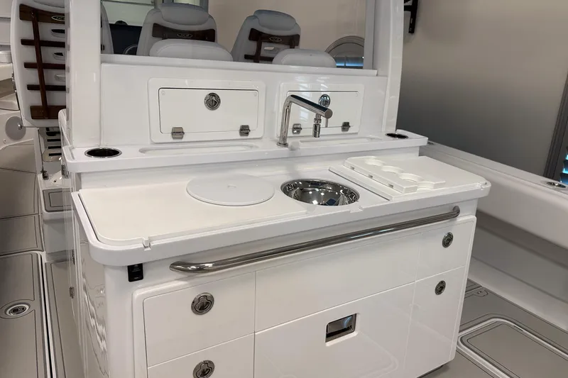 Slide: The Image of 2025 HCB 42 Lujo boat interior with sleek white kitchenette and modern amenities. - 43