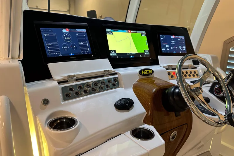 Slide: The Image of 2025 HCB 42 Lujo boat dashboard with advanced navigation screens and controls. - 45