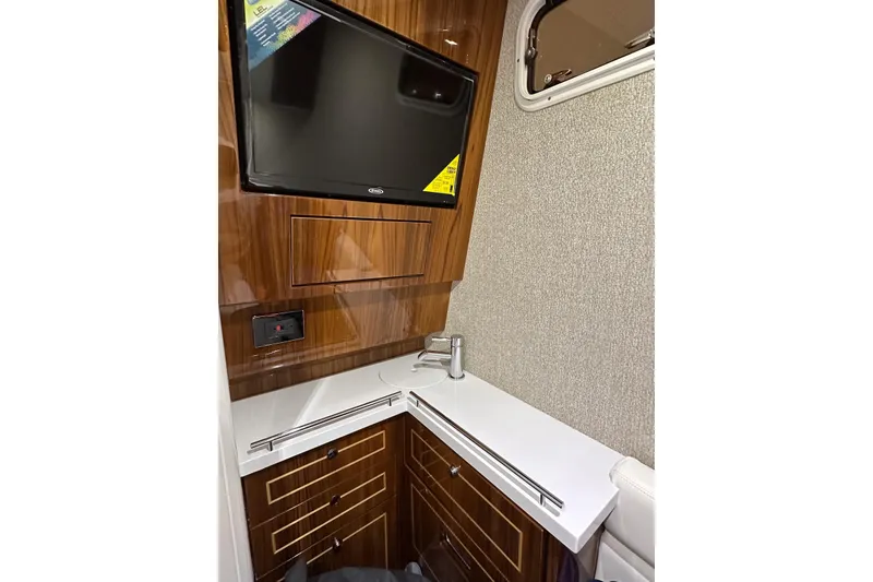 Slide: The Image of Interior of 2025 HCB 42 Lujo boat with TV, wood cabinetry, and countertop. - 54