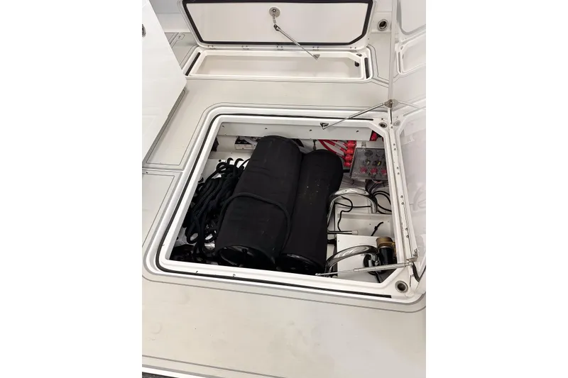 Slide: The Image of Open storage compartment in 2025 HCB 42 Lujo boat, showing equipment and wiring. - 56