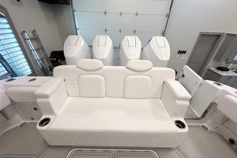 Slide: The Image of Luxurious white seating on 2025 HCB 42 Lujo boat with powerful engines in a garage setting. - 67