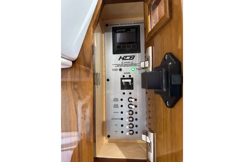 Slide: The Image of Electrical panel inside 2025 HCB 42 Lujo boat, featuring control switches and indicators. - 73