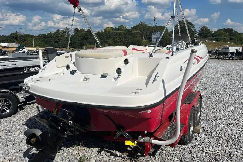 Slide: The Image of Red and white 2008 Spectra 2040 boat on trailer, parked on gravel lot under blue sky. - 4