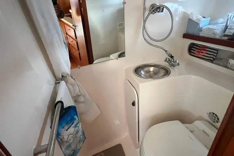 Slide: The Image of 2003 Tiara Yachts 3100 Open galley with sink, stove, and wooden cabinetry. - 16