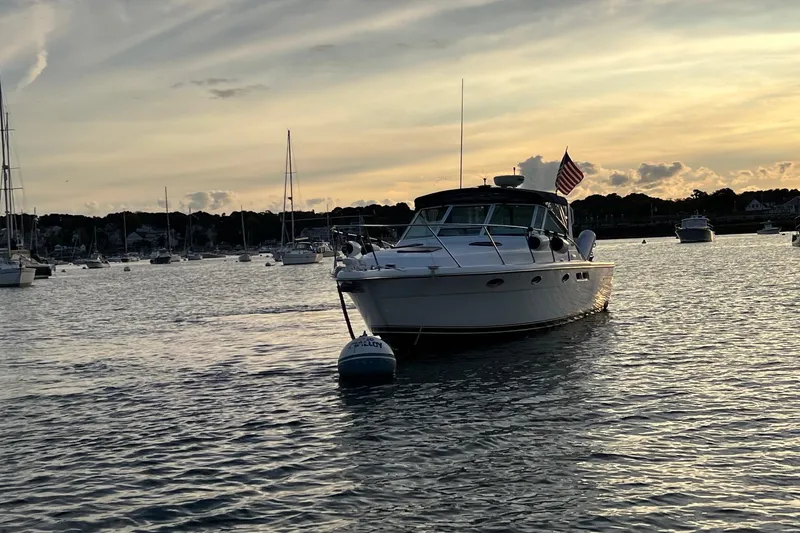Slide: The Image of 2003 Tiara Yachts 3100 Open anchored in a serene harbor at sunset. - 2