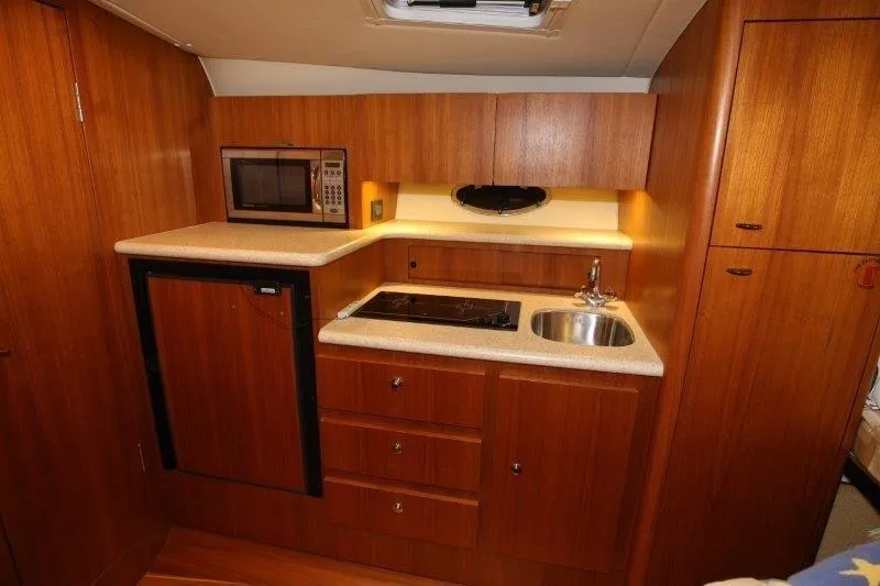 Slide: The Image of Interior of 2003 Tiara Yachts 3100 Open, featuring cozy seating and wooden finishes. - 25