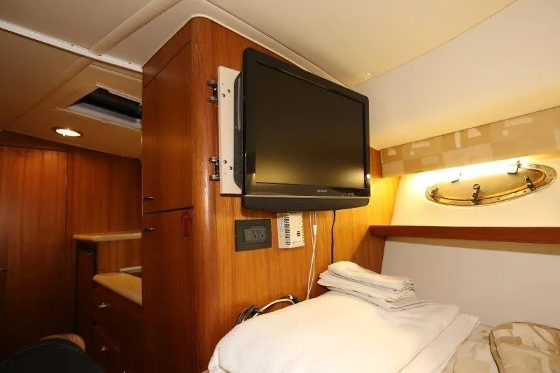 Slide: The Image of 2003 Tiara Yachts 3100 Open galley with wood cabinetry, sink, stove, and microwave. - 26
