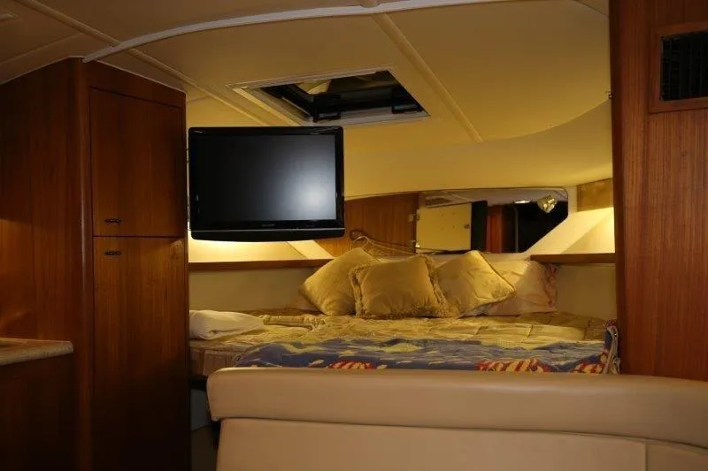 Slide: The Image of 2003 Tiara Yachts 3100 Open cabin interior with TV and cozy bedding. - 27