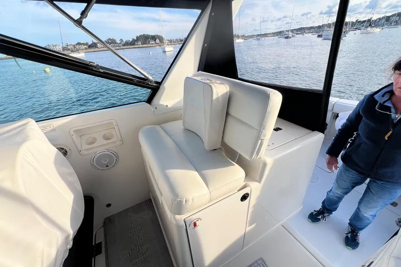 Slide: The Image of 2003 Tiara Yachts 3100 Open interior with white seating and window view. - 7