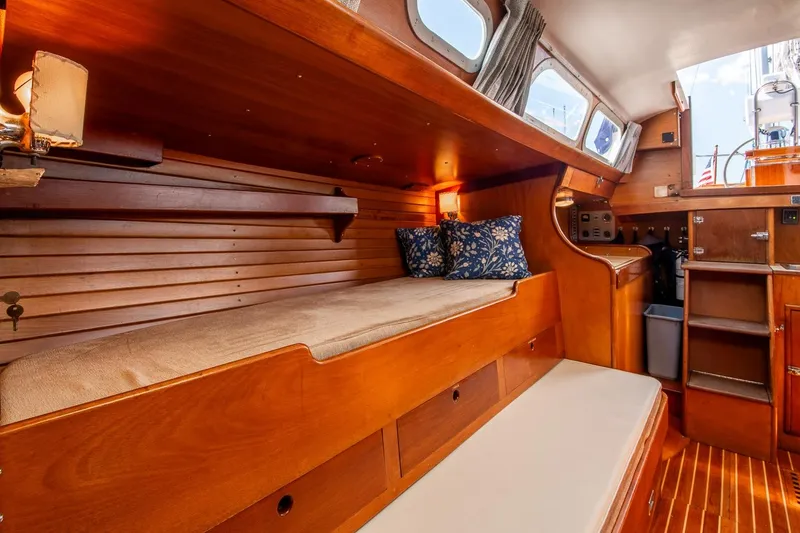 Slide: The Image of Interior of 1971 Hinckley Bermuda 40 Custom Yawl, featuring wooden cabinetry and cozy seating. - 24