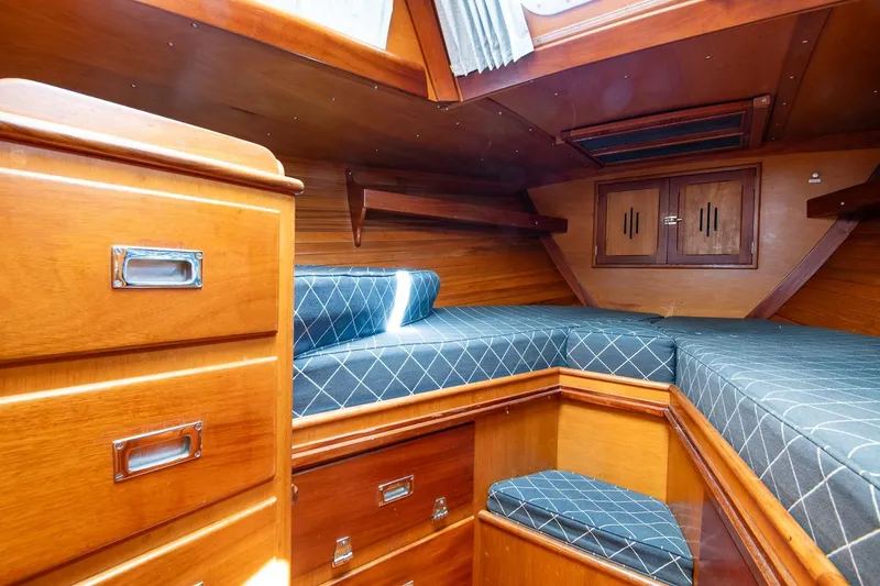 Slide: The Image of 1971 Hinckley Bermuda 40 Custom Yawl cabin with wooden interior and blue cushioned seating. - 32