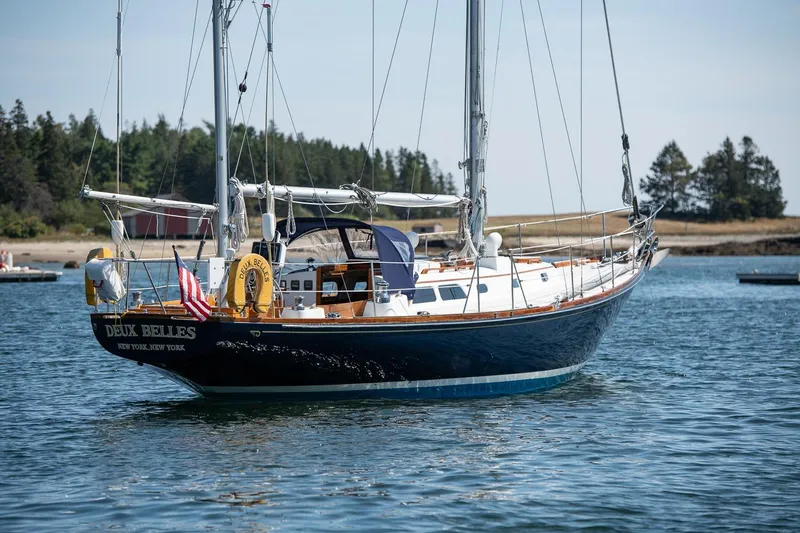Slide: The Image of 1971 Hinckley Bermuda 40 Custom Yawl sailing on calm waters, forested shoreline in background. - 2