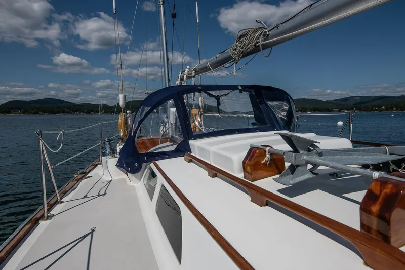 Slide: The Image of 1971 Hinckley Bermuda 40 Custom Yawl sailing on a serene lake under blue skies. - 21