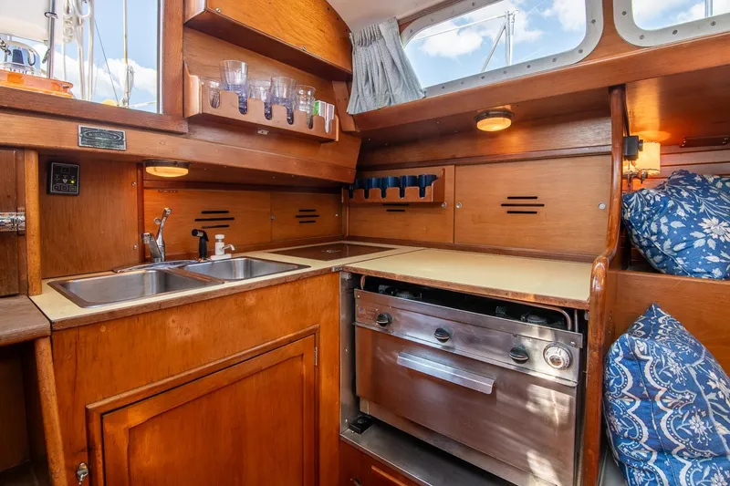 Slide: The Image of Interior of 1971 Hinckley Bermuda 40 Custom Yawl, featuring a wooden galley with stove and sink. - 26