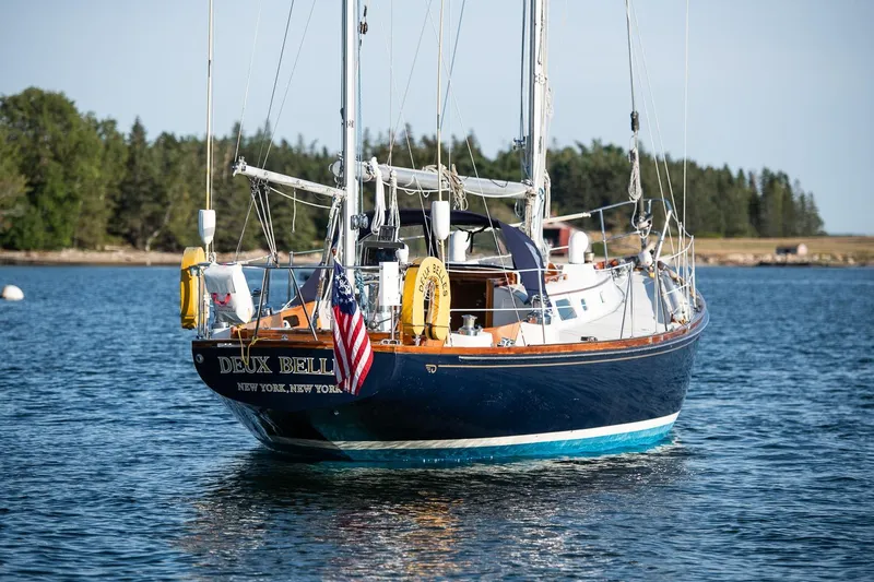 Slide: The Image of Hinckley Bermuda 40 Custom Yawl, 1971, sailing on calm waters with forested shoreline. - 3