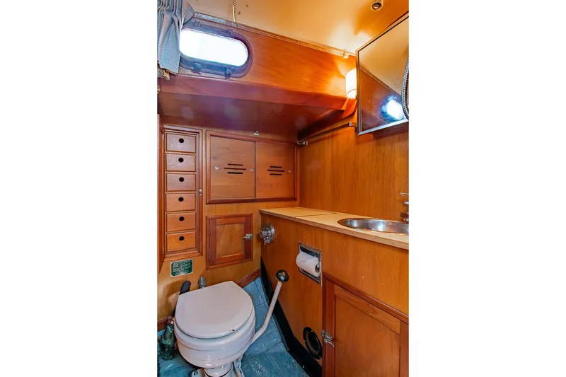 Slide: The Image of 1971 Hinckley Bermuda 40 Custom Yawl bathroom with wooden cabinetry and compact design. - 36