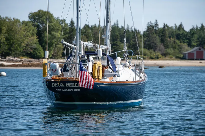 Slide: The Image of 1971 Hinckley Bermuda 40 Custom Yawl sailing near a scenic shoreline. - 4