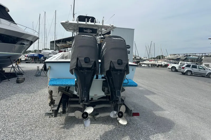 Slide: The Image of 1999 Jupiter 31 Cuddy boat with dual outboard motors in a marina setting. - 13