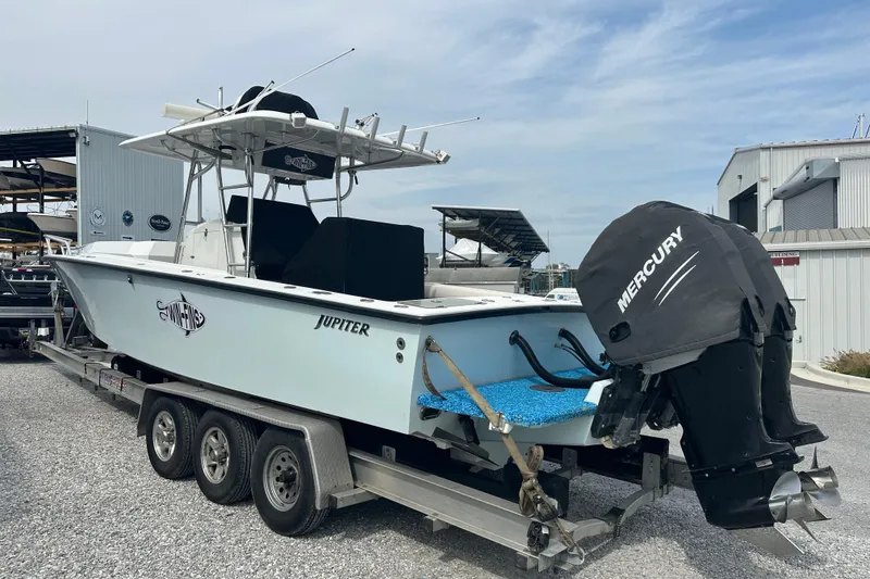 Slide: The Image of 1999 Jupiter 31 Cuddy boat on trailer with Mercury outboard engine, parked outdoors. - 18