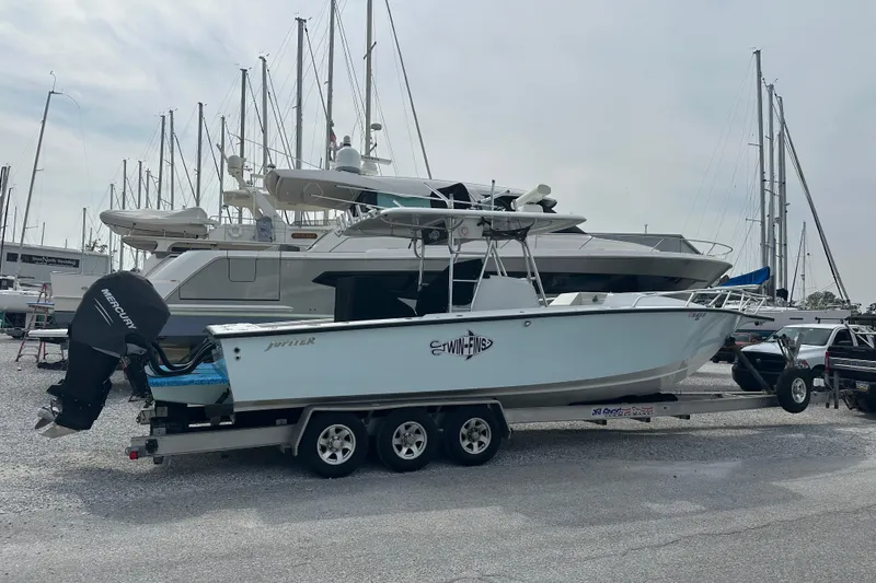 Slide: The Image of 1999 Jupiter 31 Cuddy boat on trailer, parked in marina with other vessels. - 20