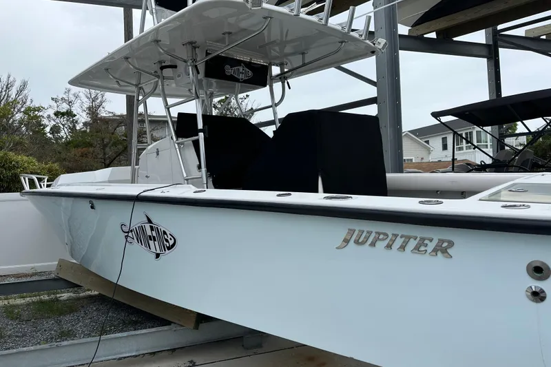 Slide: The Image of 1999 Jupiter 31 Cuddy boat on a lift, featuring sleek design and branding. - 21