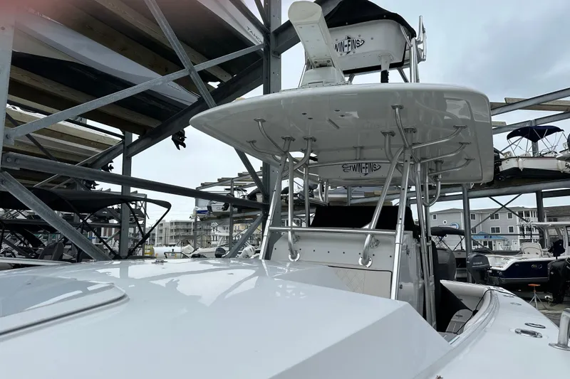 Slide: The Image of 1999 Jupiter 31 Cuddy boat in storage, featuring a sturdy T-top and sleek design. - 26