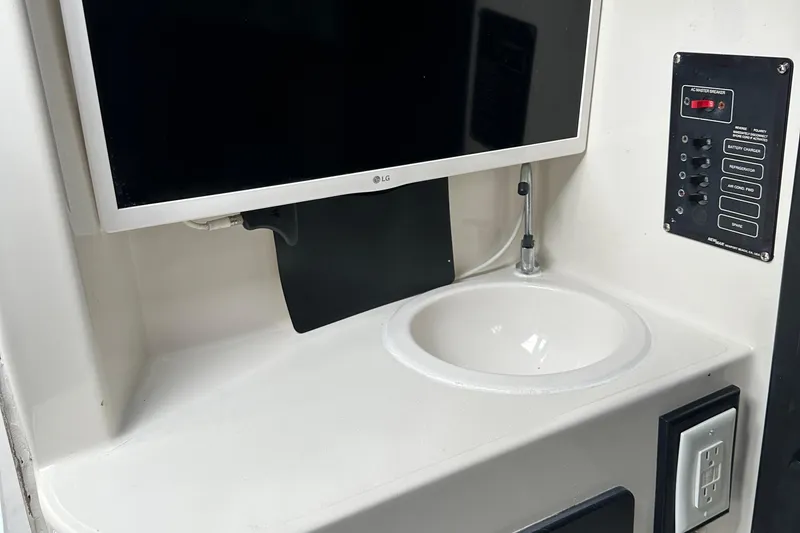 Slide: The Image of Interior of 1999 Jupiter 31 Cuddy with TV, sink, and control panel. - 28