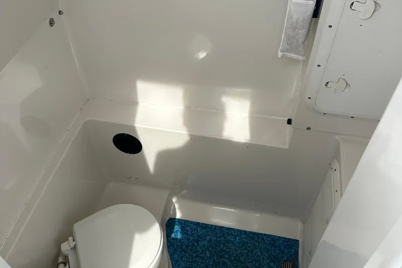 Slide: The Image of Interior of 1999 Jupiter 31 Cuddy boat, featuring compact marine toilet. - 3