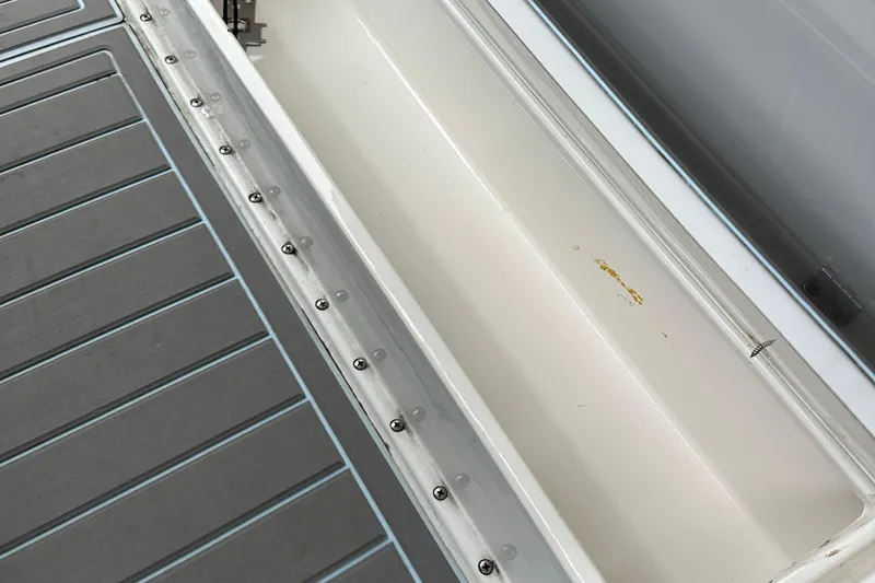 Slide: The Image of 1999 Jupiter 31 Cuddy boat storage compartment with gray non-slip deck surface. - 37