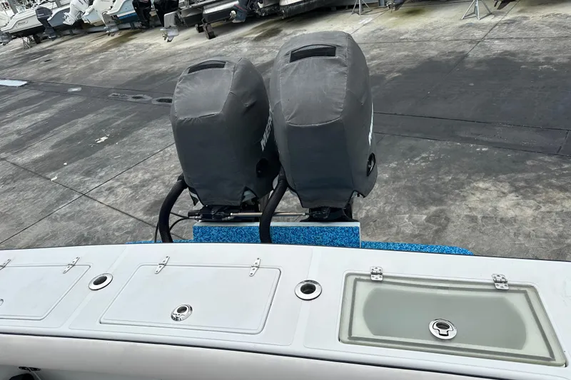 Slide: The Image of 1999 Jupiter 31 Cuddy boat with dual covered outboard motors on a concrete dock. - 44