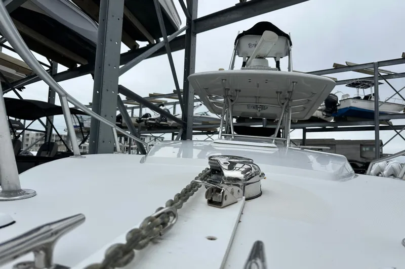 Slide: The Image of 1999 Jupiter 31 Cuddy boat in storage, showcasing anchor chain and deck details. - 47
