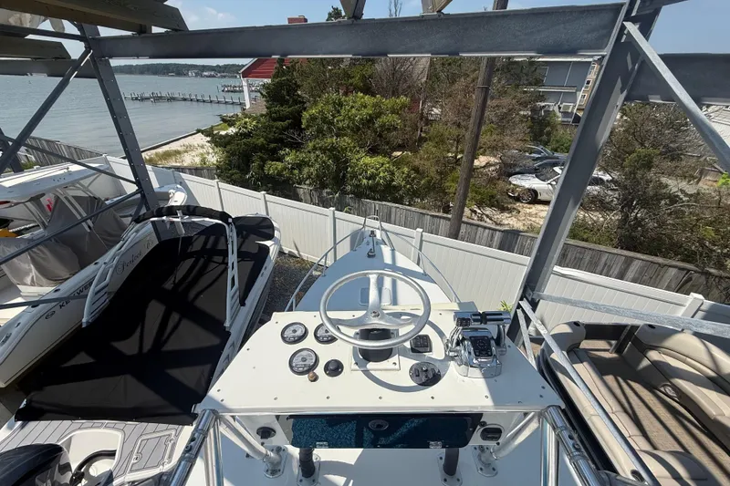 Slide: The Image of 1999 Jupiter 31 Cuddy boat helm with ocean view and nearby dock. - 7