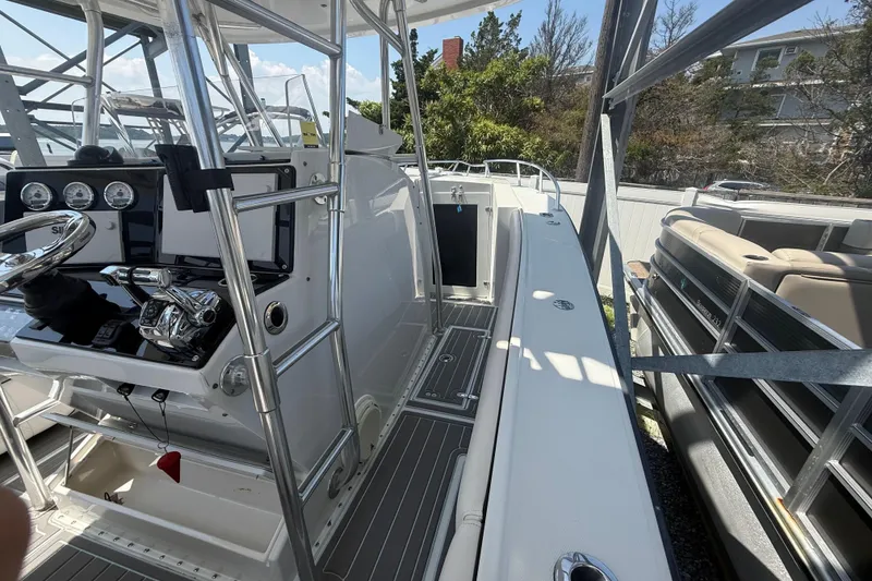 Slide: The Image of 1999 Jupiter 31 Cuddy boat interior with steering console and seating area. - 9