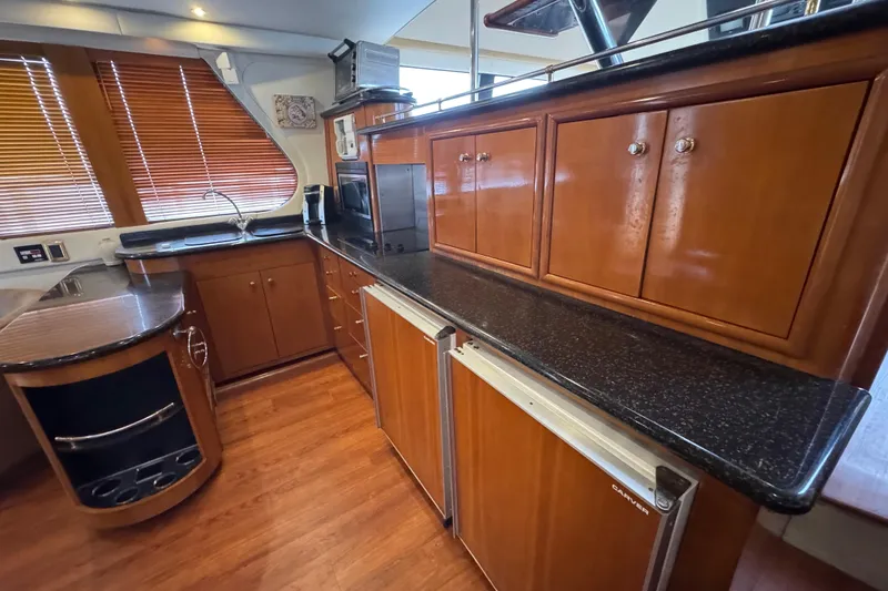 Slide: The Image of Luxurious kitchen interior of 2001 Carver 530 Voyager Pilothouse yacht with wood cabinetry. - 25