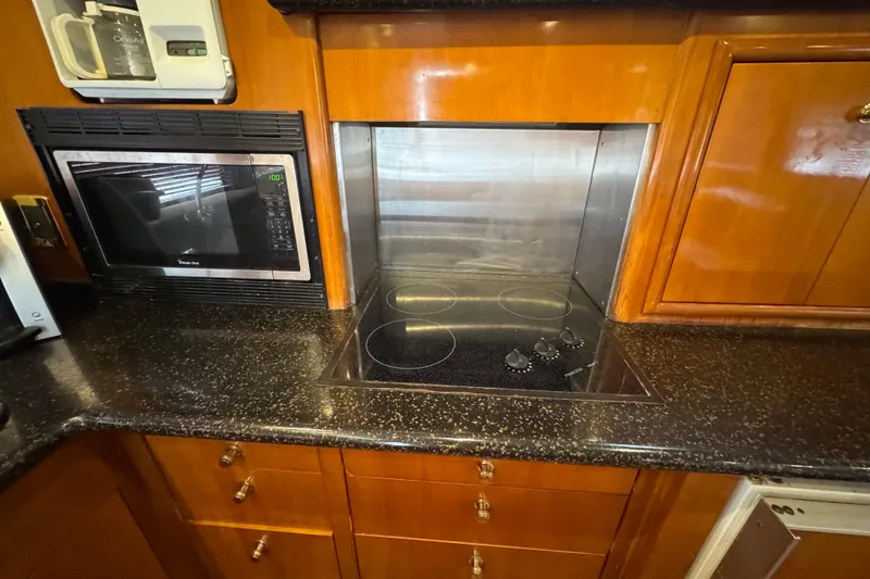 Slide: The Image of 2001 Carver 530 Voyager Pilothouse kitchen with stove and microwave. - 26