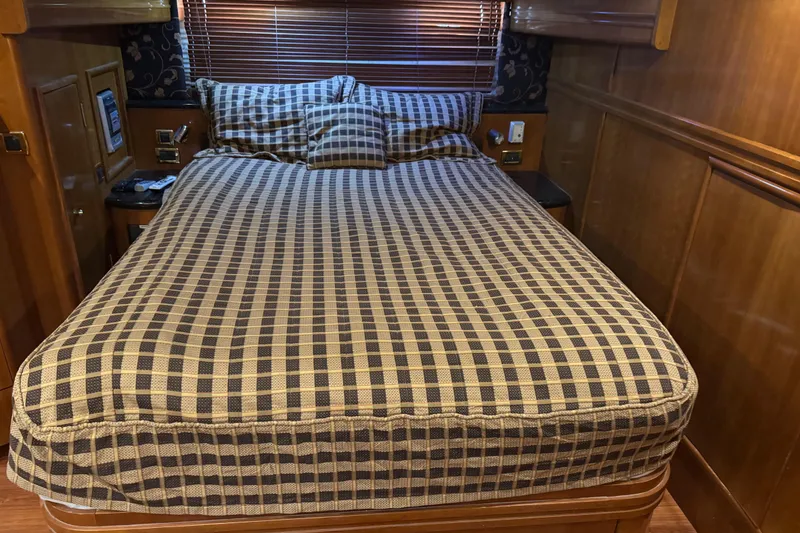 Slide: The Image of Luxurious bedroom interior of 2001 Carver 530 Voyager Pilothouse yacht with checkered bedding. - 27