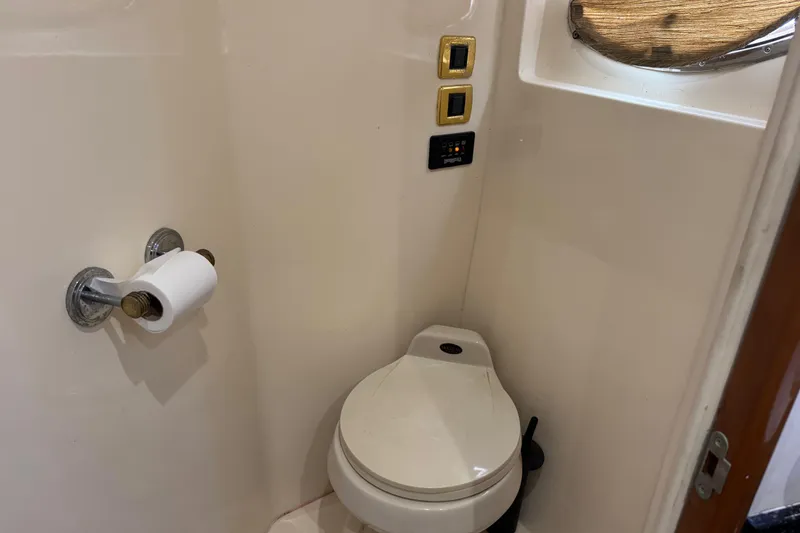 Slide: The Image of 2001 Carver 530 Voyager Pilothouse bathroom with toilet, toilet paper holder, and control panel. - 34