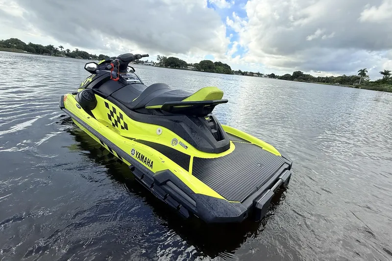 Slide: The Image of 2023 Yamaha WaveRunner VX110 jet ski on a calm lake under cloudy skies. - 13