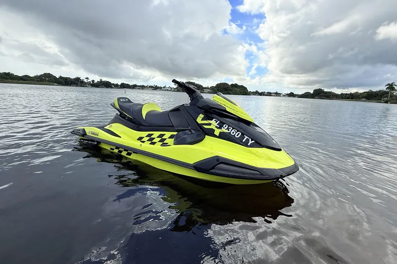 Slide: The Image of 2023 Yamaha WaveRunner VX110 jet ski on calm water under cloudy sky. - 16
