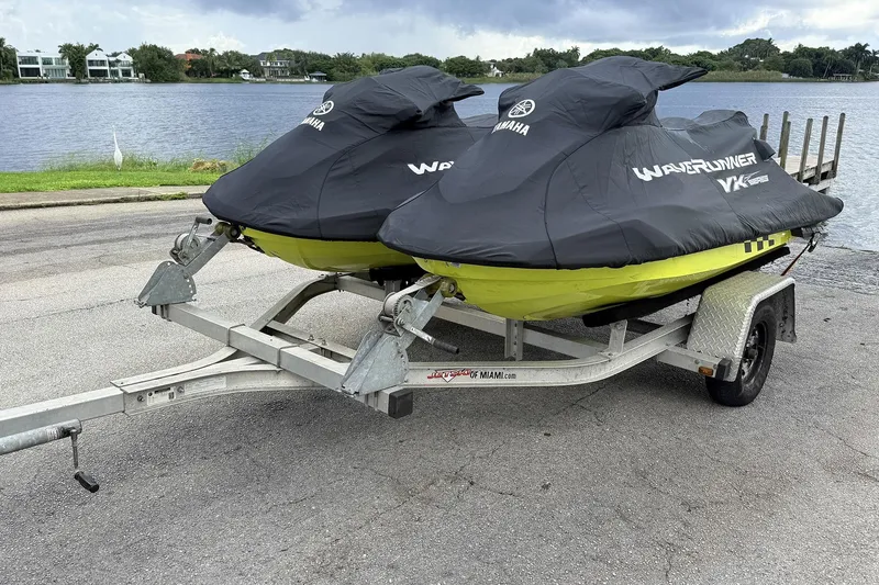 Slide: The Image of 2023 Yamaha WaveRunner VX110 jet skis on trailer by a lake. - 24