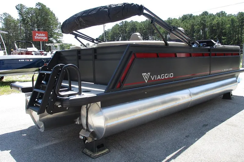 Slide: The Image of 2025 Viaggio Lago X22U pontoon boat with sleek design and ladder, parked outdoors. - 7