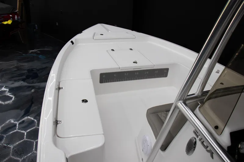 Slide: The Image of 2025 Savannah 210X boat interior with sleek white deck and storage compartments. - 13