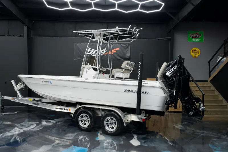 Slide: The Image of 2025 Savannah 210X boat on trailer in showroom with modern lighting. - 3