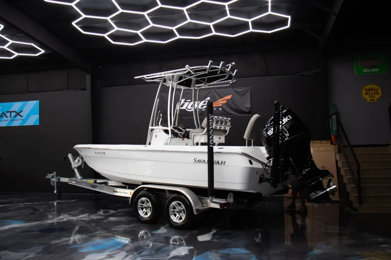 Slide: The Image of 2025 Savannah 210X boat on trailer in showroom with modern lighting. - 4